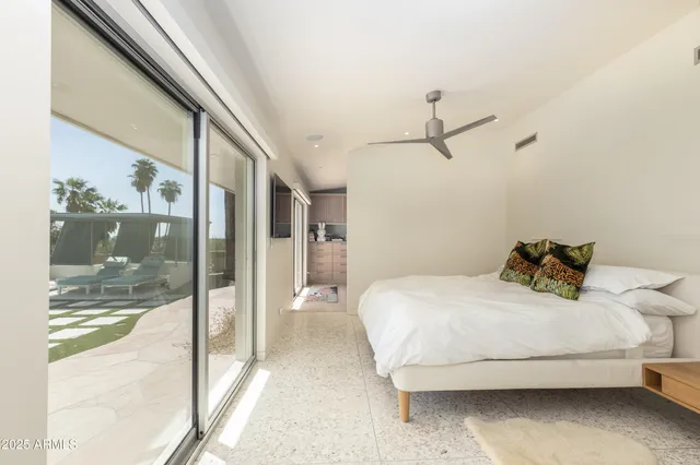 a bedroom with a bed and a large mirror