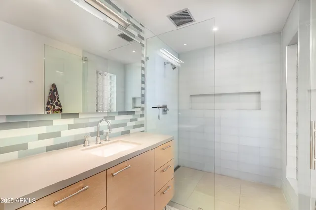a bathroom with a granite countertop sink a bathtub and a mirror
