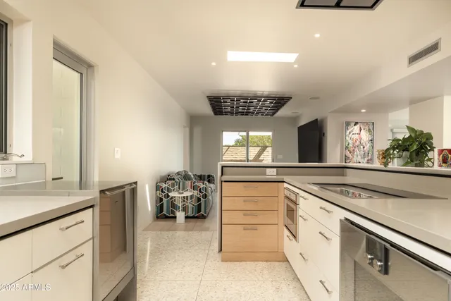 a kitchen with stainless steel appliances granite countertop a sink and a refrigerator