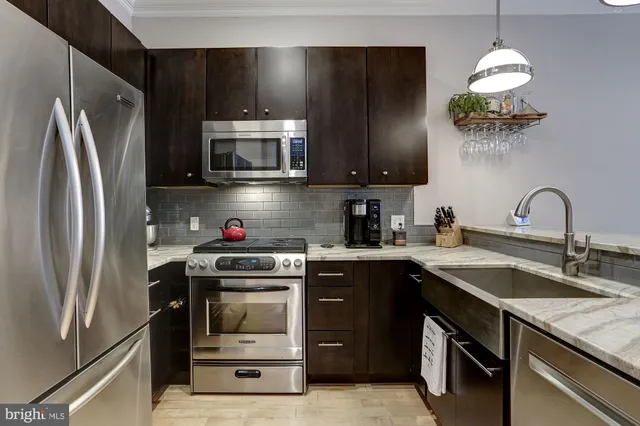 a kitchen with stainless steel appliances granite countertop a sink stove and refrigerator