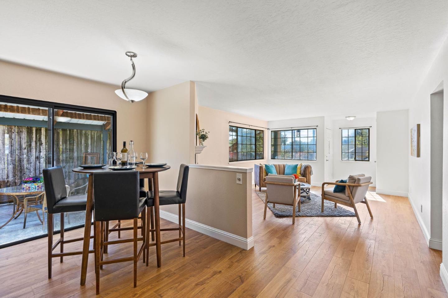 276 Hames Road Watsonville, CA 95076 - Photo 13 of 43 a dining room with wooden floor a chandelier a glass table and chairs