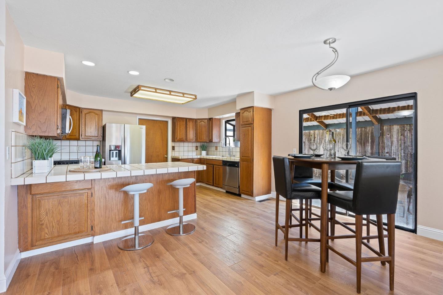 276 Hames Road Watsonville, CA 95076 - Photo 14 of 43 a kitchen with stainless steel appliances granite countertop wooden floor window dining table and chairs