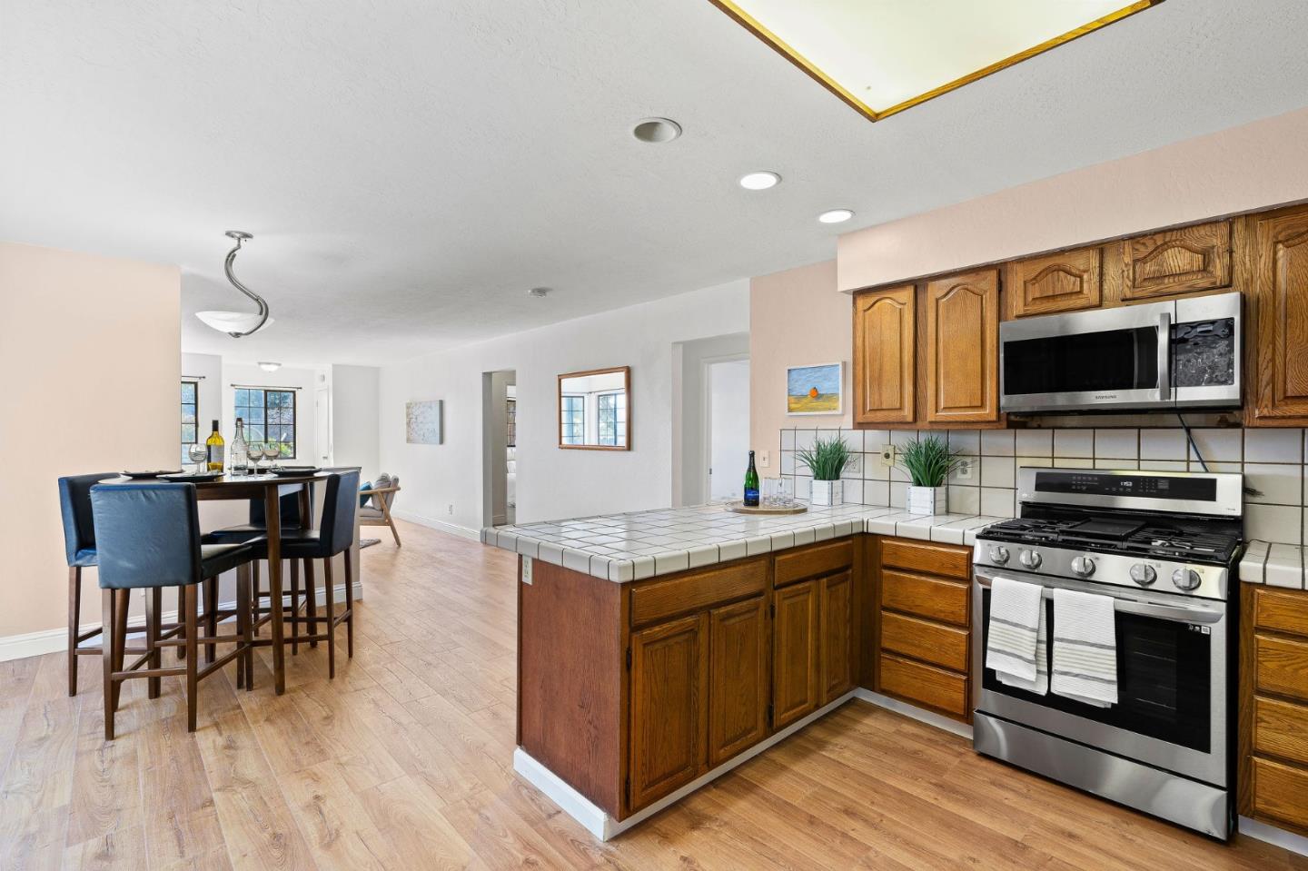 276 Hames Road Watsonville, CA 95076 - Photo 19 of 43 a kitchen with stainless steel appliances granite countertop a stove top oven a sink dishwasher a dining table and chairs with wooden floor