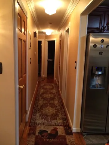 a view of a hallway with wooden floor and staircase