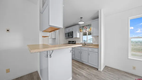a kitchen with stainless steel appliances granite countertop a sink and wooden cabinets
