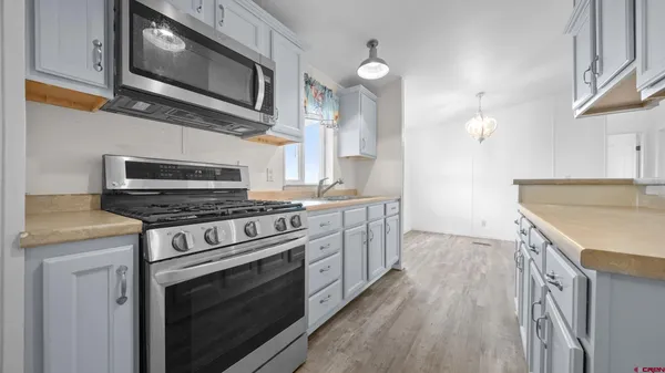 a kitchen with stainless steel appliances a stove microwave and cabinets