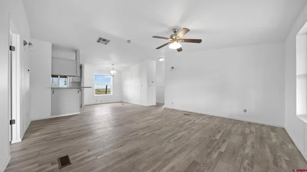 a view of a kitchen with wooden floor and a kitchen space