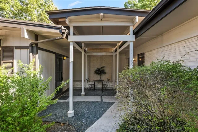 a view of a porch with a table and chairs and potted plants
