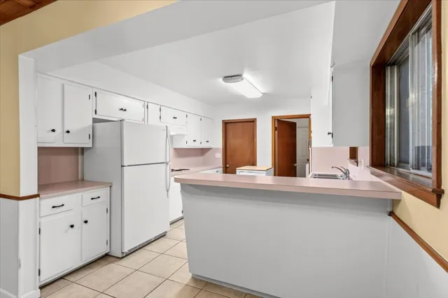 a kitchen with stainless steel appliances a refrigerator and white cabinets