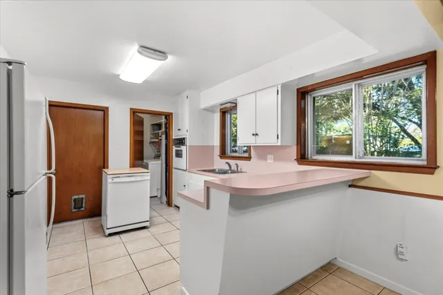 a kitchen with a sink and large windows