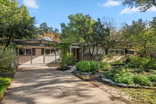 a front view of a house with a yard and potted plants
