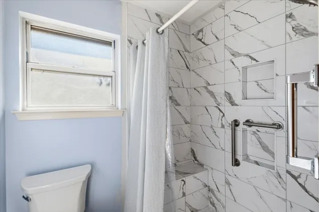 a bathroom with a toilet and a shower