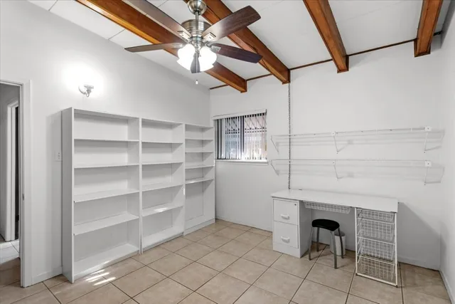 a view of a livingroom with chairs and chandelier fan