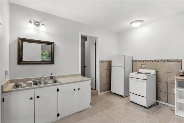 a kitchen with a sink cabinets and refrigerator