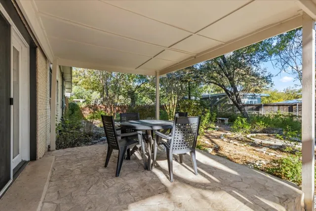 a patio with yard glass top table and chairs