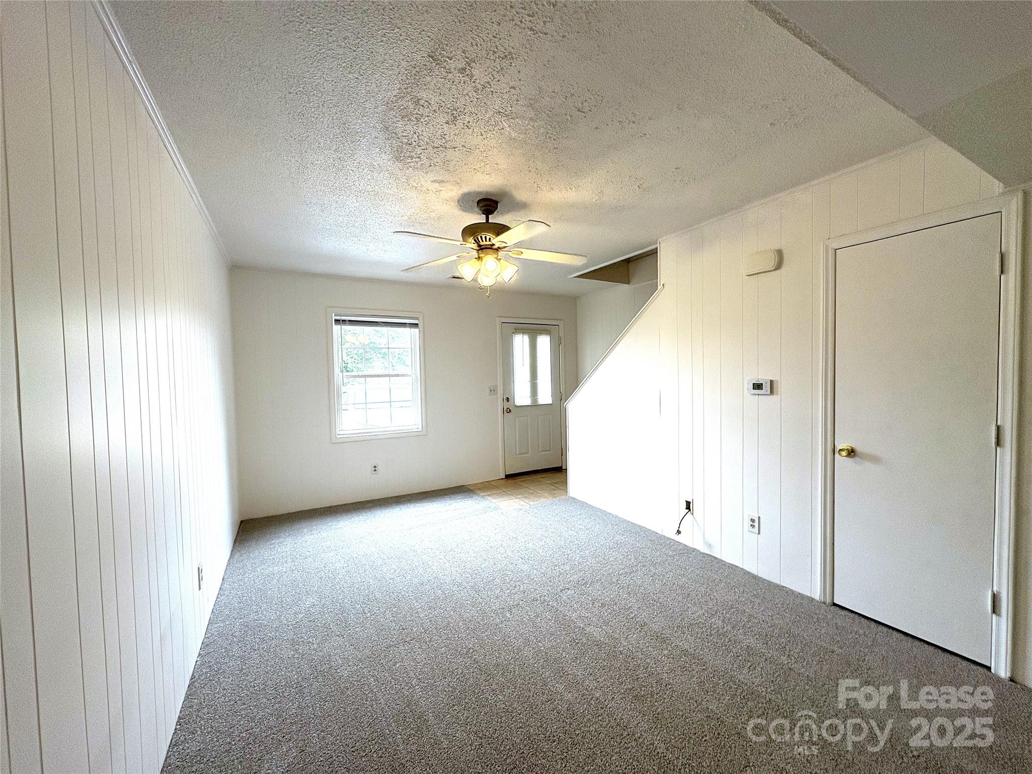 108 Durham Road Stanley, NC 28164 - Photo 4 of 20 an empty room with windows and chandelier fan