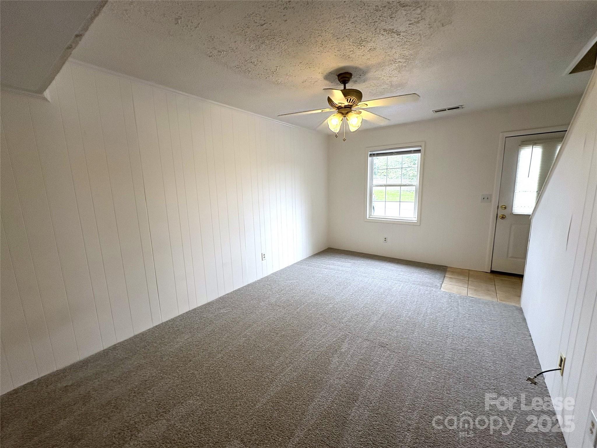 108 Durham Road Stanley, NC 28164 - Photo 5 of 20 an empty room with windows and chandelier fan