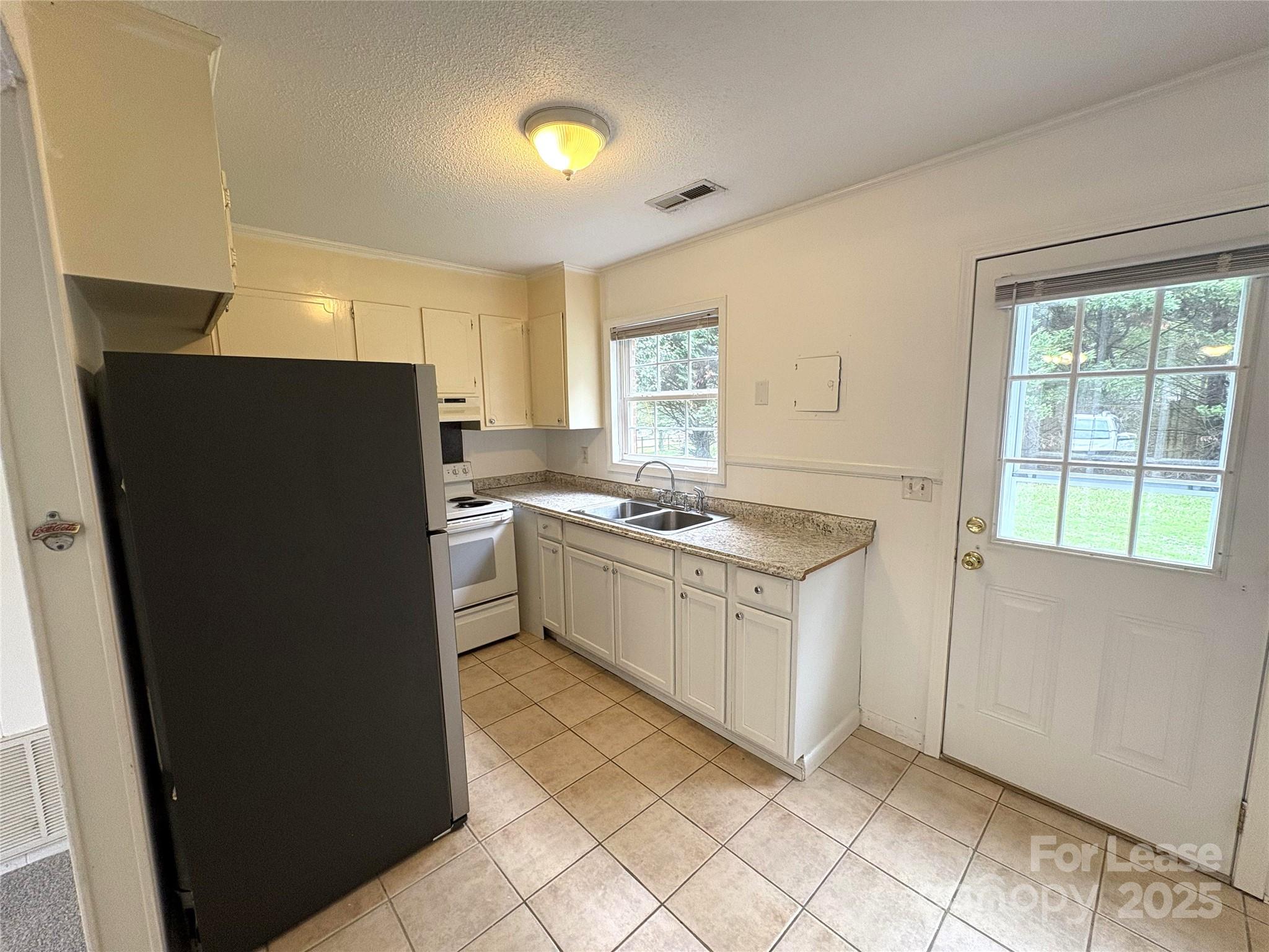 108 Durham Road Stanley, NC 28164 - Photo 8 of 20 a kitchen with a sink a refrigerator a window and cabinets