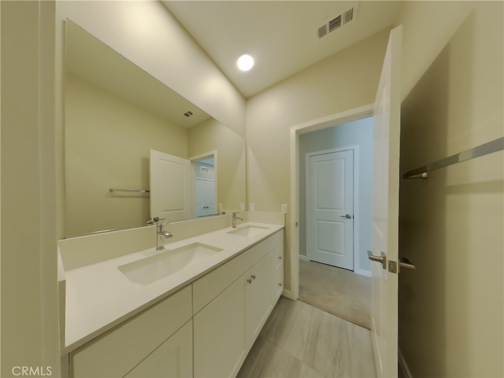 36591 Pepino Court Wildomar, CA 92595 - Photo 11 of 29 a bathroom with a double vanity sink mirror and shower