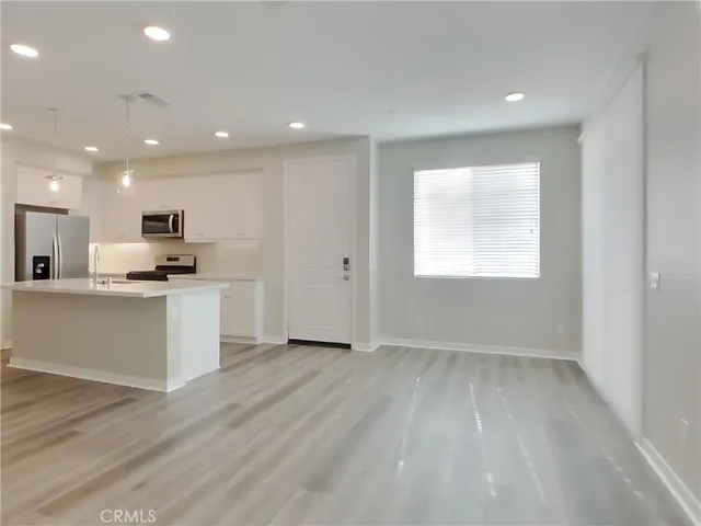 a view of kitchen with granite countertop cabinets and refrigerator