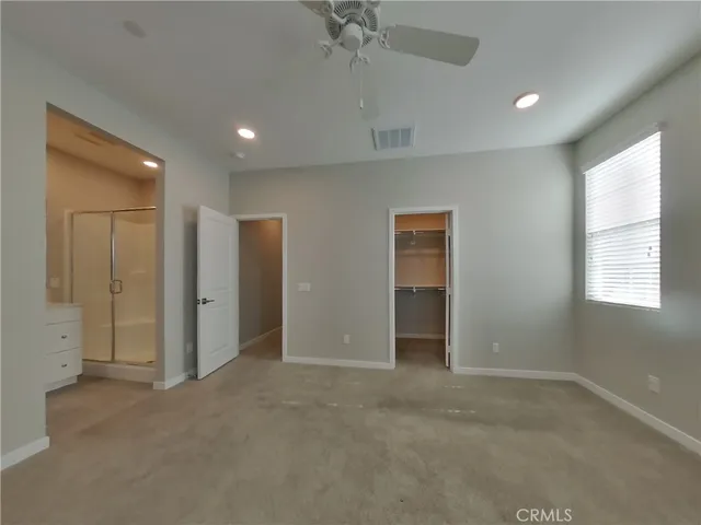 an empty room with fan and windows