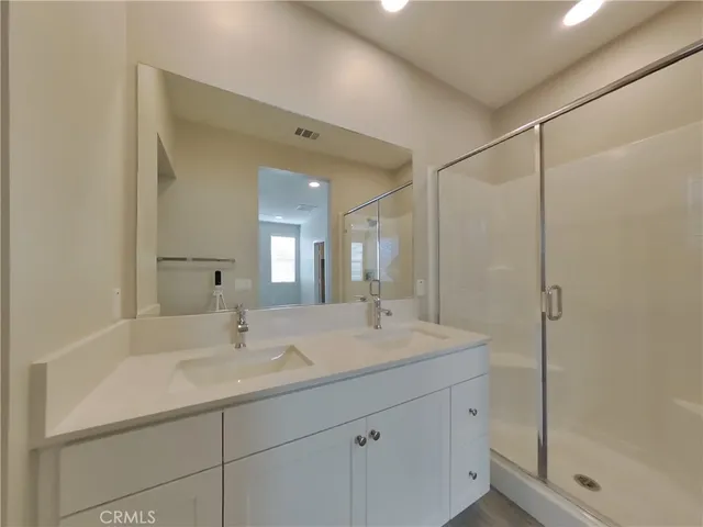 a bathroom with a shower sink and mirror