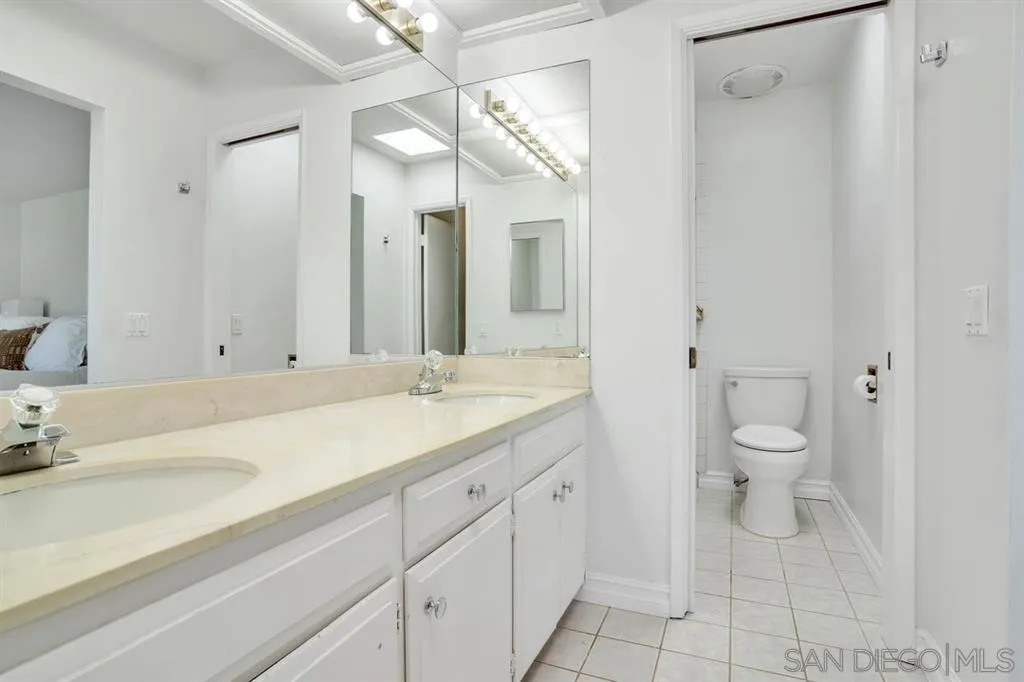 3047 Via De Caballo Encinitas, CA 92024 - Photo 19 of 25 a bathroom with a granite countertop sink a toilet and a mirror