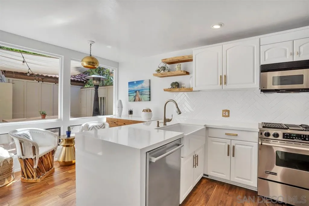 3047 Via De Caballo Encinitas, CA 92024 - Photo 4 of 25 a kitchen with stainless steel appliances granite countertop a sink and cabinets with wooden floor