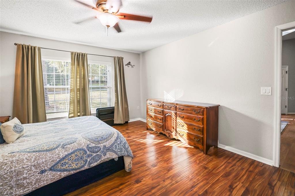 8412 Christopher Lane Weeki Wachee, FL 34613 - Photo 18 of 39 a bedroom with a bed and wooden floor
