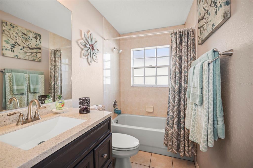 8412 Christopher Lane Weeki Wachee, FL 34613 - Photo 24 of 39 a bathroom with a granite countertop sink a toilet and a large mirror