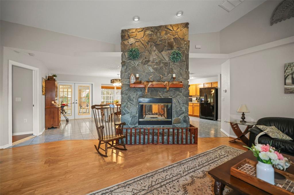 8412 Christopher Lane Weeki Wachee, FL 34613 - Photo 28 of 39 a living room with furniture a dining table and a fireplace