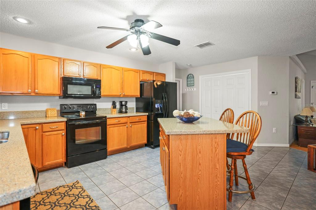 8412 Christopher Lane Weeki Wachee, FL 34613 - Photo 30 of 39 a kitchen with granite countertop cabinets a dining table and chairs