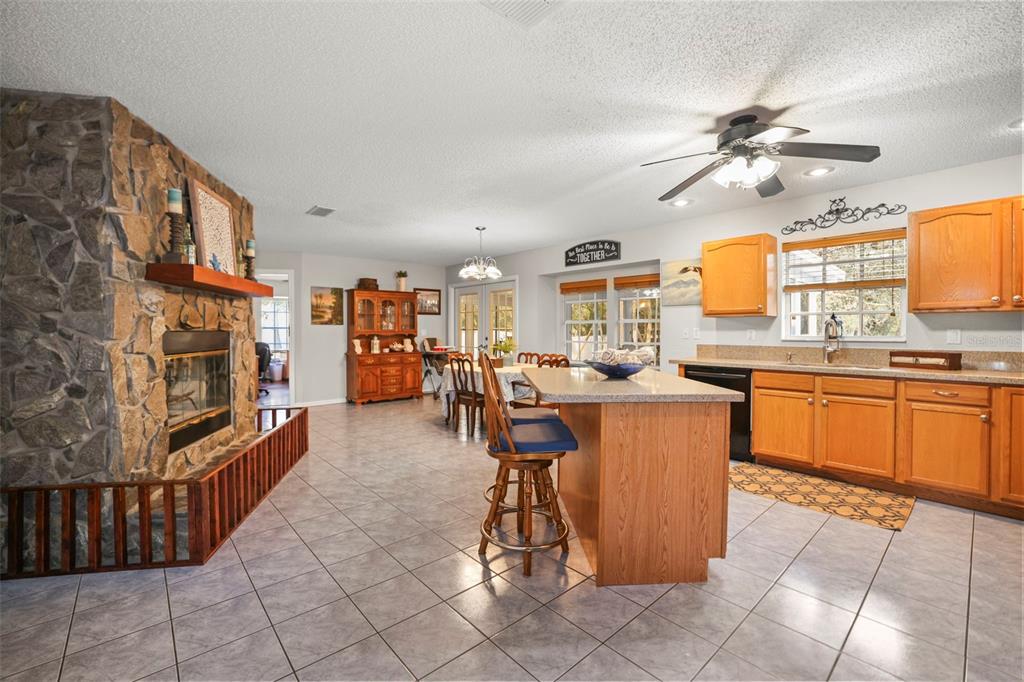 8412 Christopher Lane Weeki Wachee, FL 34613 - Photo 6 of 43 a kitchen with stainless steel appliances kitchen island granite countertop a table chairs in it and a window