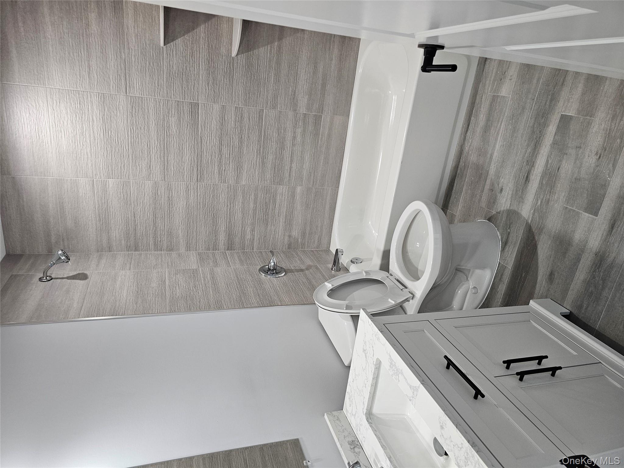 13 North Swezeytown Road Middle Island, NY 11953 - Photo 2 of 9 a bathroom with a granite countertop toilet a sink and bathtub