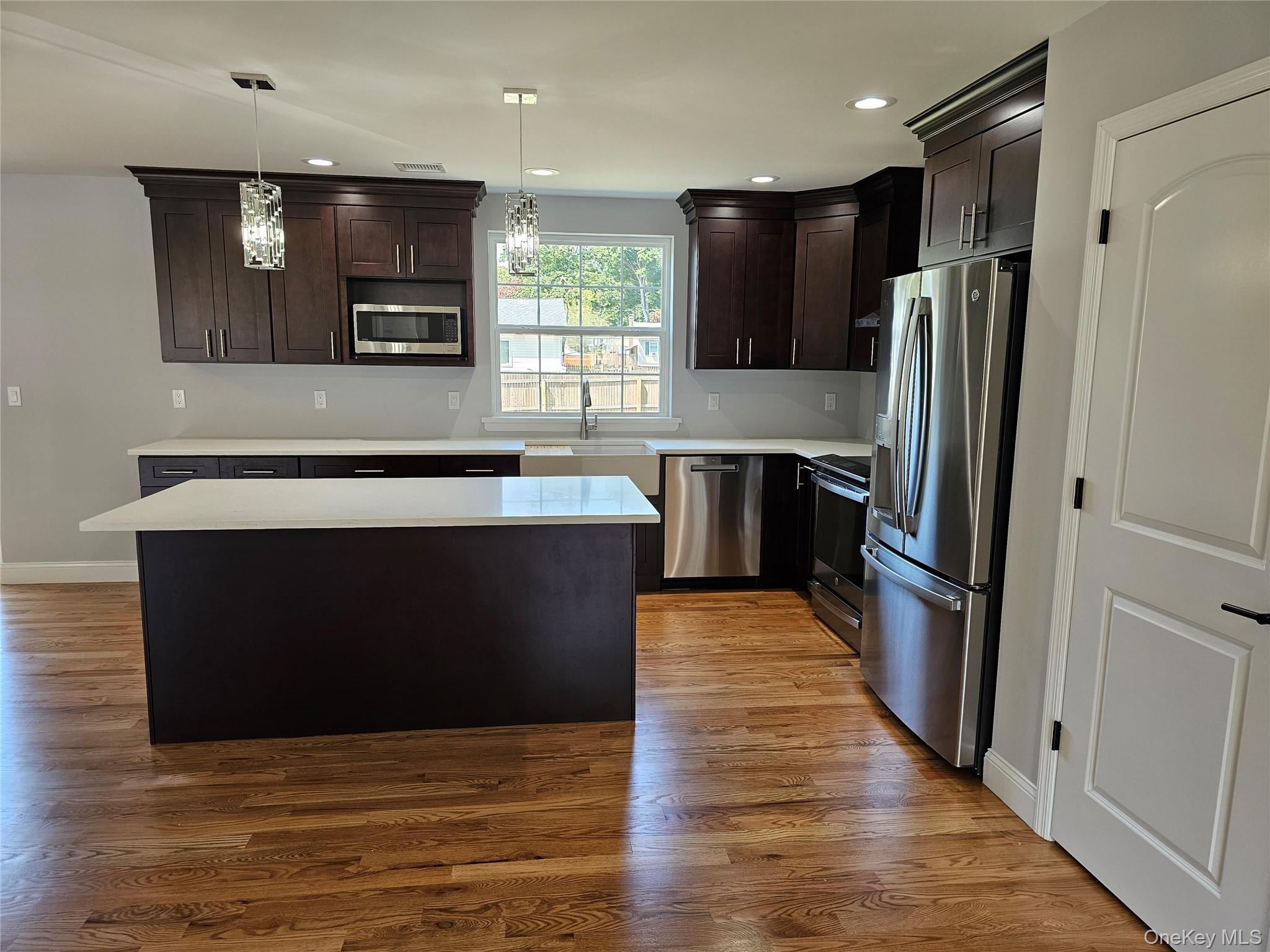 13 North Swezeytown Road Middle Island, NY 11953 - Photo 3 of 9 a kitchen with stainless steel appliances wooden cabinets and wooden floor