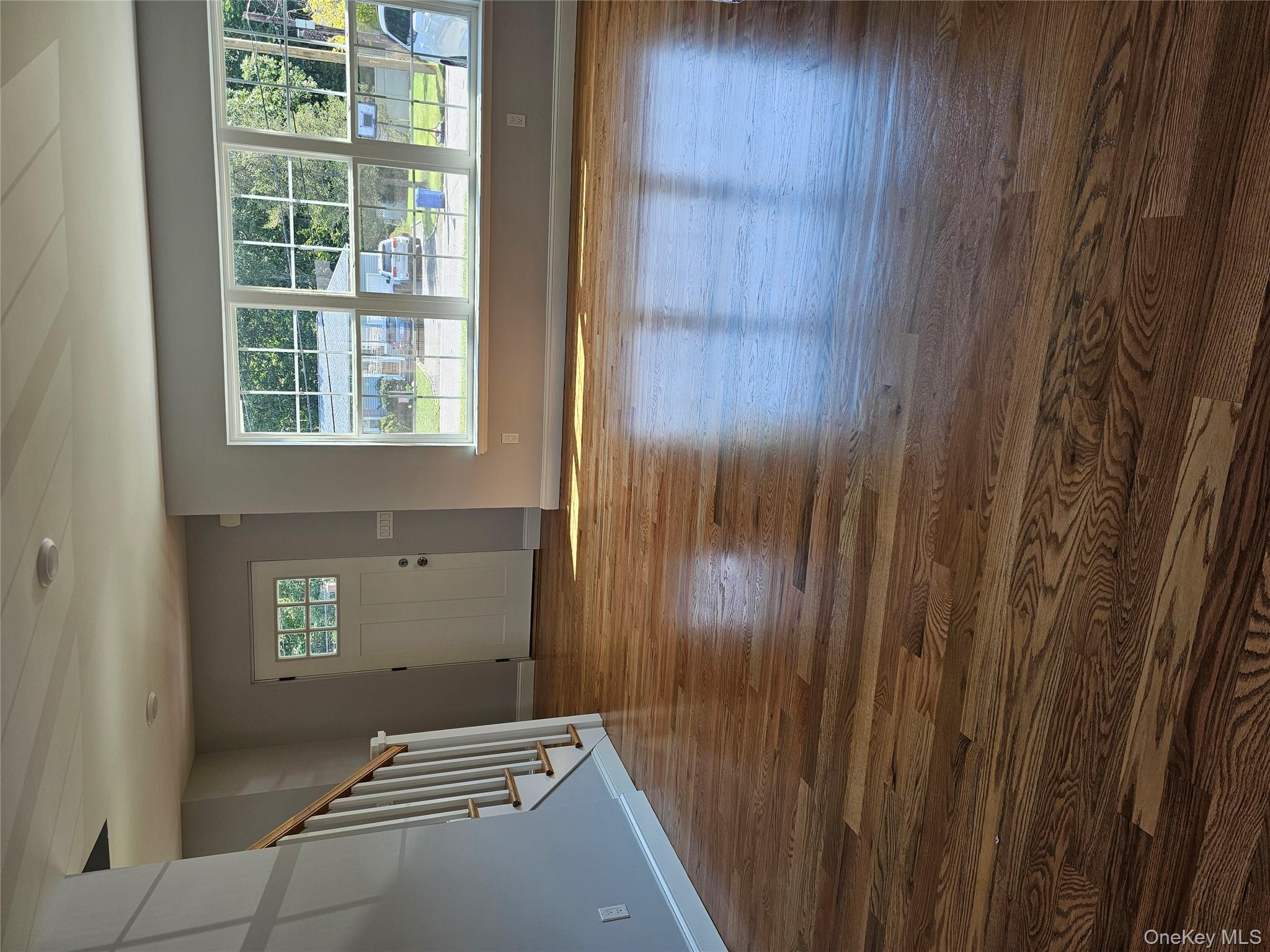 13 North Swezeytown Road Middle Island, NY 11953 - Photo 6 of 9 a view of an empty room with wooden floor and a window