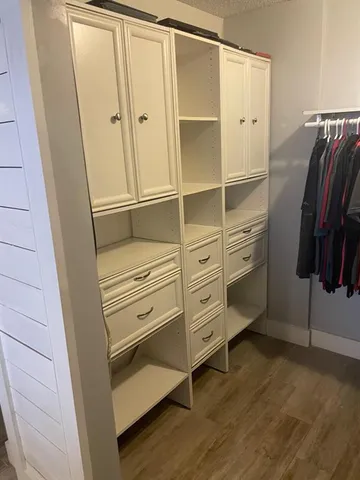 an empty room with wooden floor closet and entryway