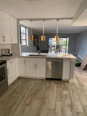 a kitchen with stainless steel appliances granite countertop a sink a stove top oven a counter space and cabinets