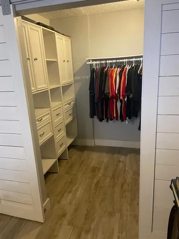 a view of walk in closet with clothes and shoes