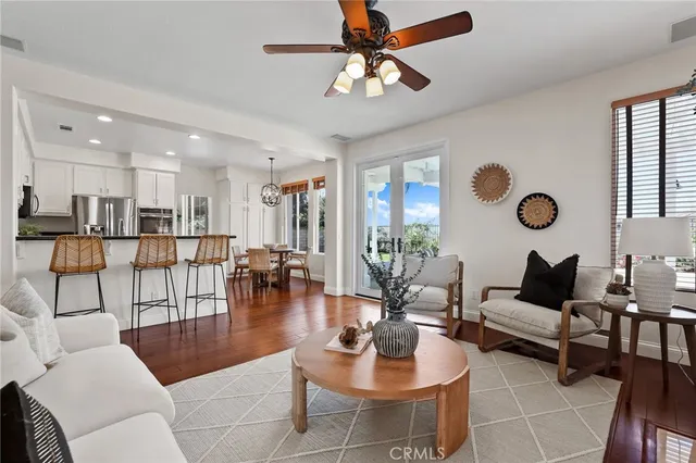 a kitchen with stainless steel appliances granite countertop a sink a stove and a refrigerator with wooden floor