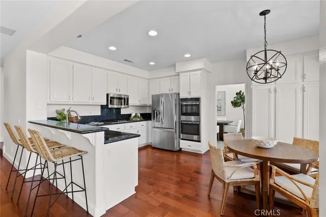 a view of a dining room and livingroom with furniture wooden floor a chandelier
