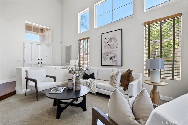 a living room with couches and a dining table with wooden floor