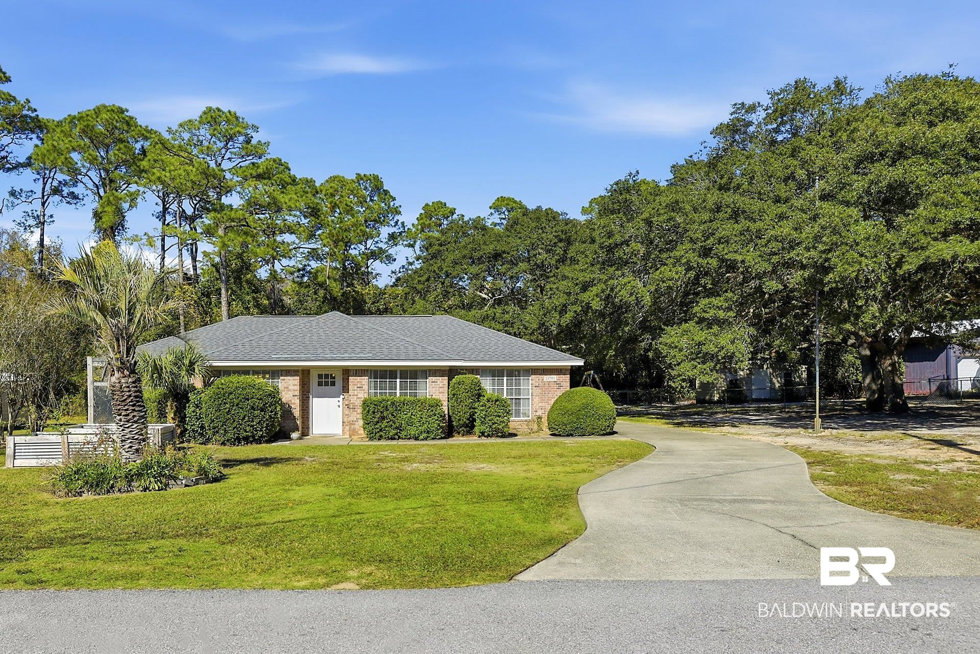 25793 Bonito Avenue Orange Beach, AL 36561 - Photo 1 of 27 View of front of property featuring brick siding, a front lawn, and concrete driveway