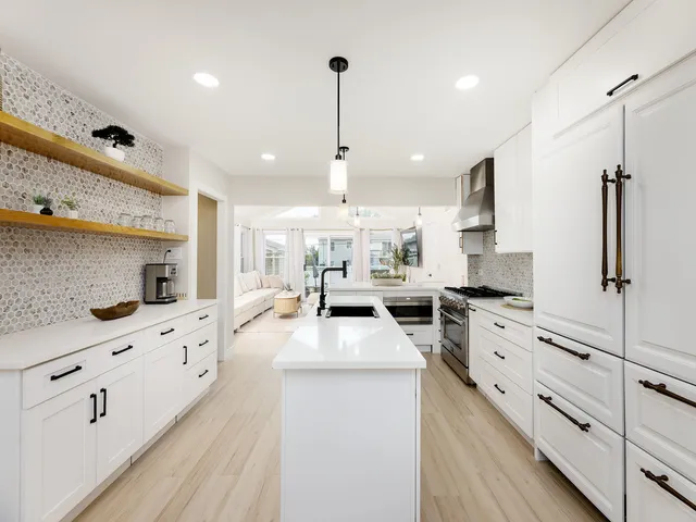 a large kitchen with stainless steel appliances kitchen island granite countertop a stove oven and a white cabinets
