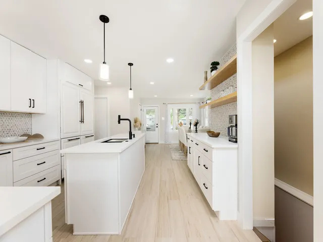a large kitchen with white cabinets and white appliances