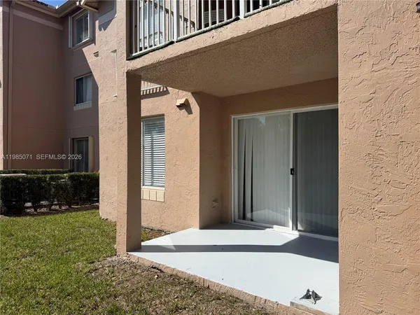 a view of a street with potted plants and a large tree