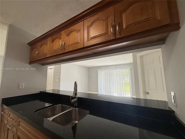 a kitchen with granite countertop a refrigerator stove and sink
