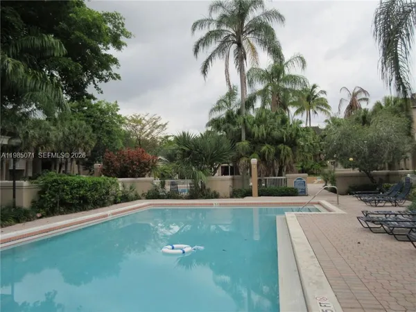 a view of a house with a yard and palm trees