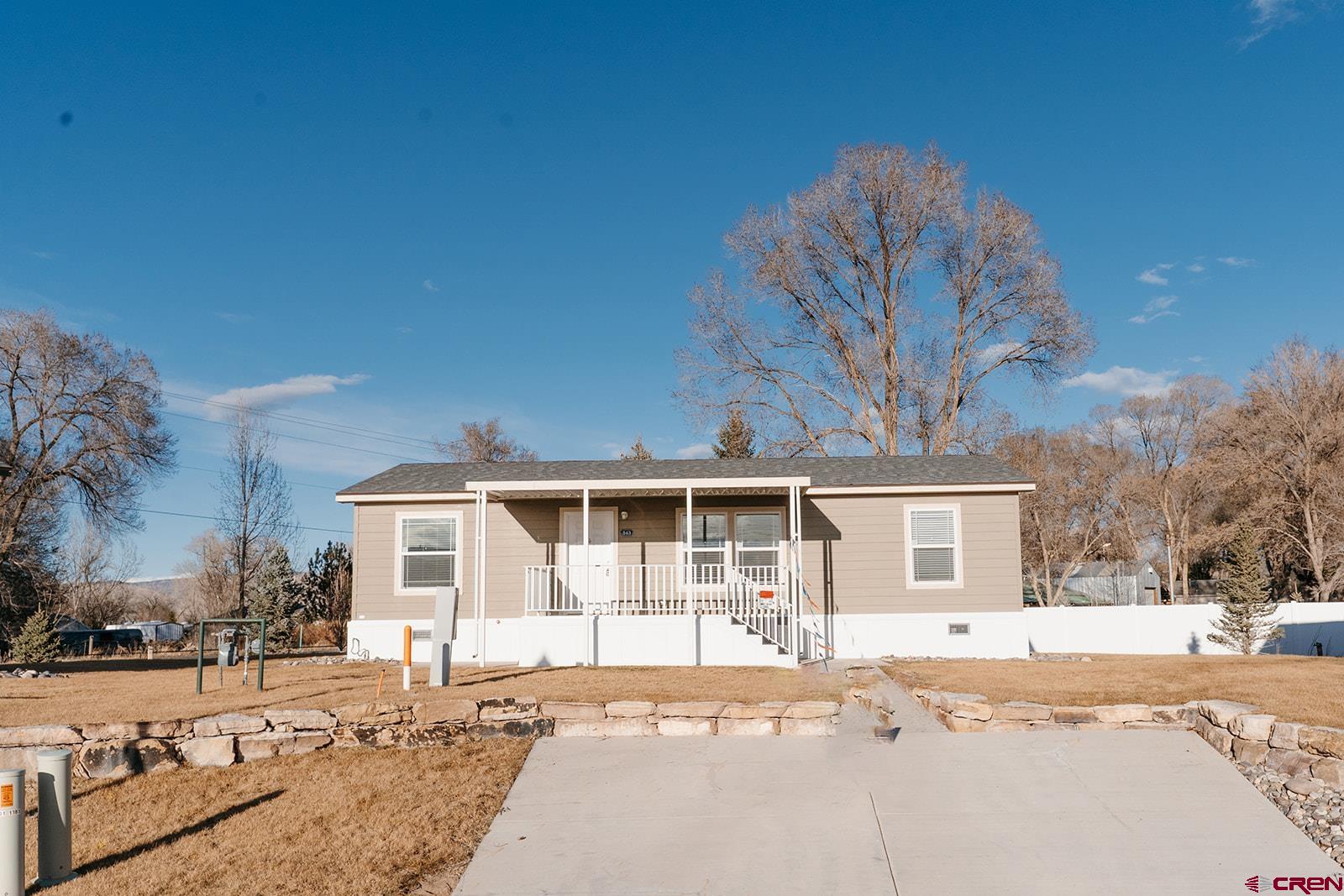 62650 Lasalle Road, Unit 343 Montrose, CO 81403 - Photo 1 of 24 a front view of a house with a dirt yard and a large tree