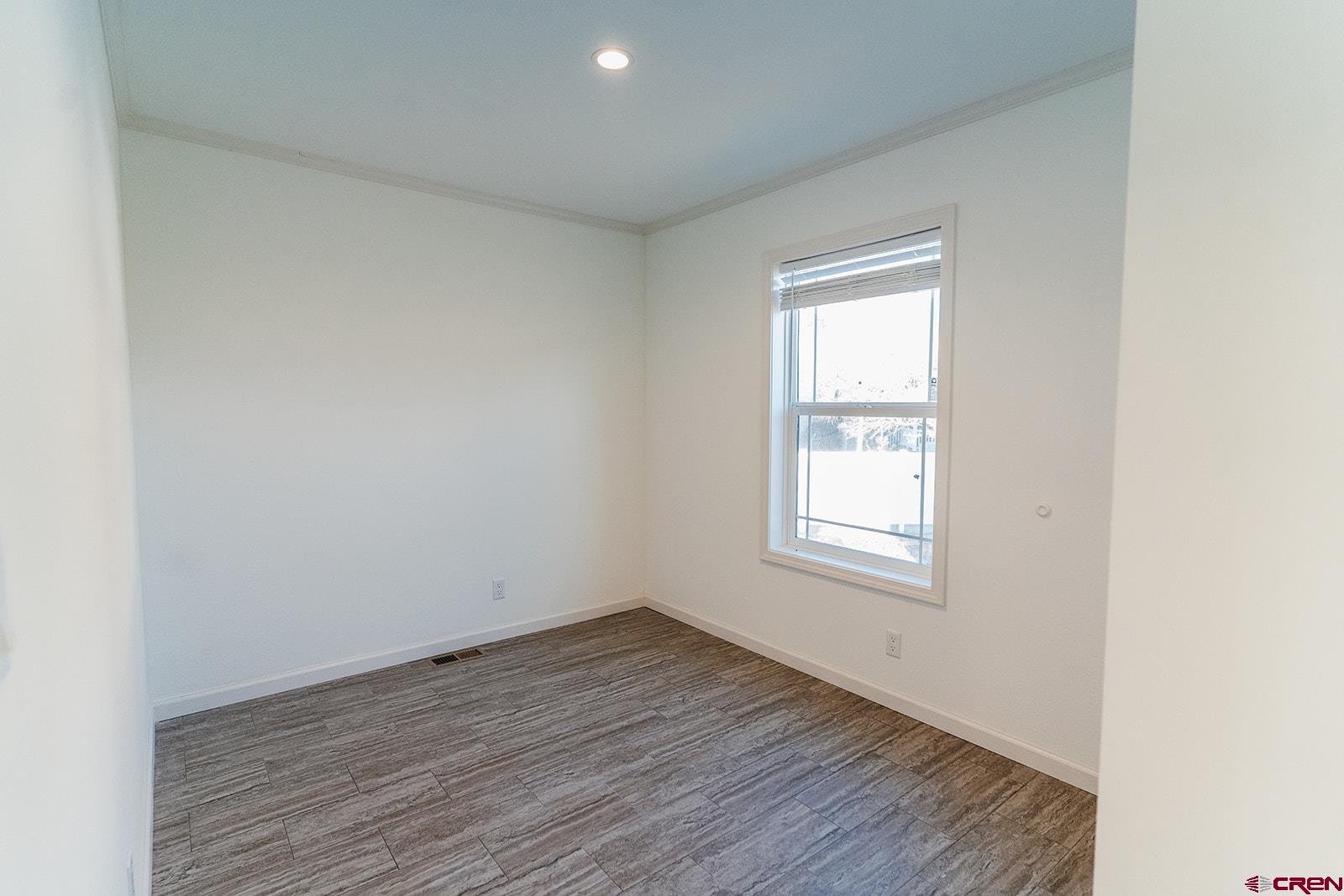 62650 Lasalle Road, Unit 343 Montrose, CO 81403 - Photo 11 of 24 an empty room with wooden floor and windows